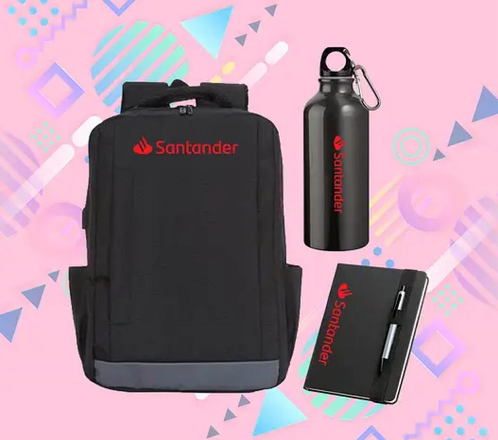 Mochila personalizada com logo Santander acompanhada de squeeze e caderno corporativo em press kit promocional