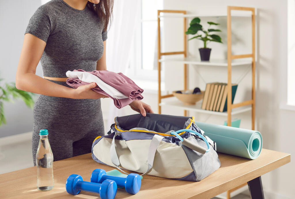 pessoa adicionando brindes esportivos em bolsa de academia