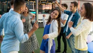 Grupo de colegas se divertindo em um evento corporativo com clima descontraído e festivo.