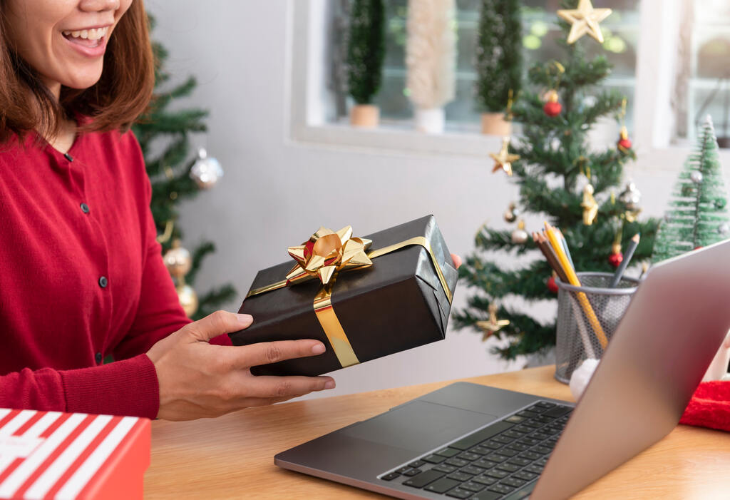 Mulher recebendo brindes gourmet em embalagem de presente