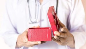 profissional abrindo caixa com lembrancinha para profissionais da saúde