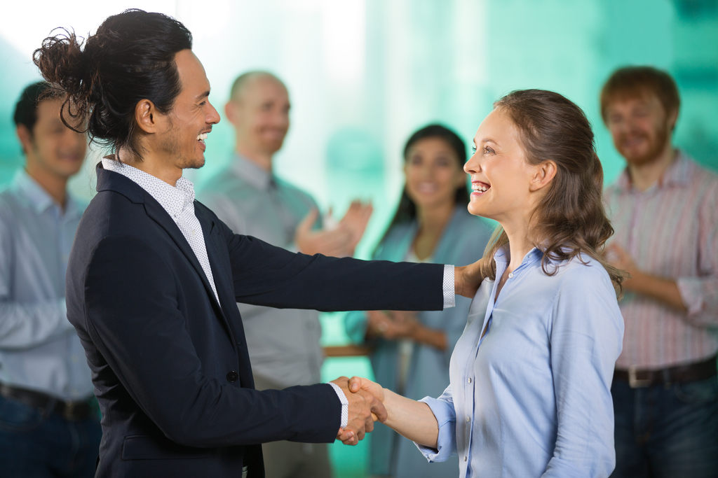 Homem sorrindo felicitando colega de negócio, representando boas vindas ao novo colaborador