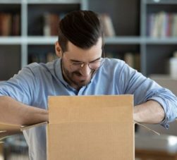 homem abrindo caixa com mimos para clientes
