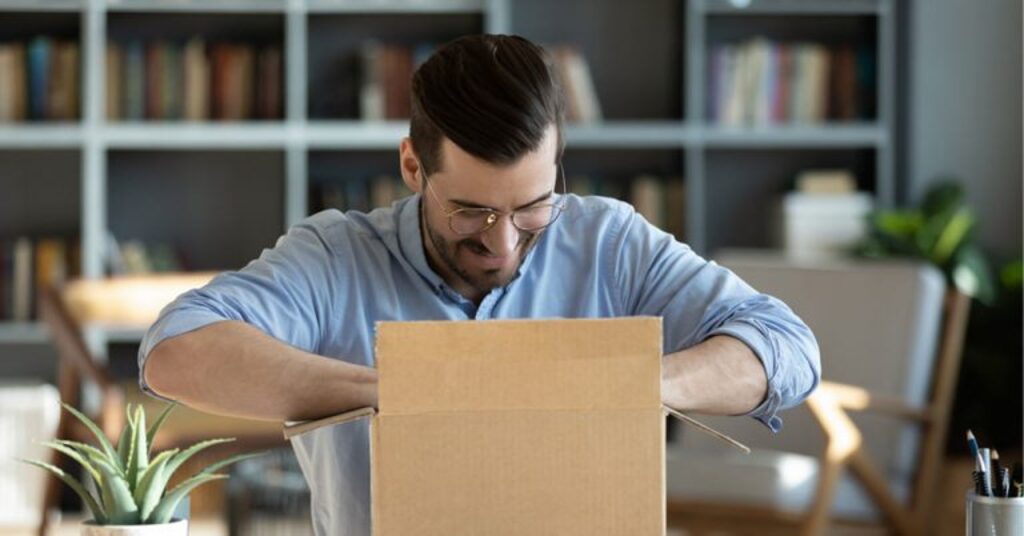 homem abrindo caixa com mimos para clientes