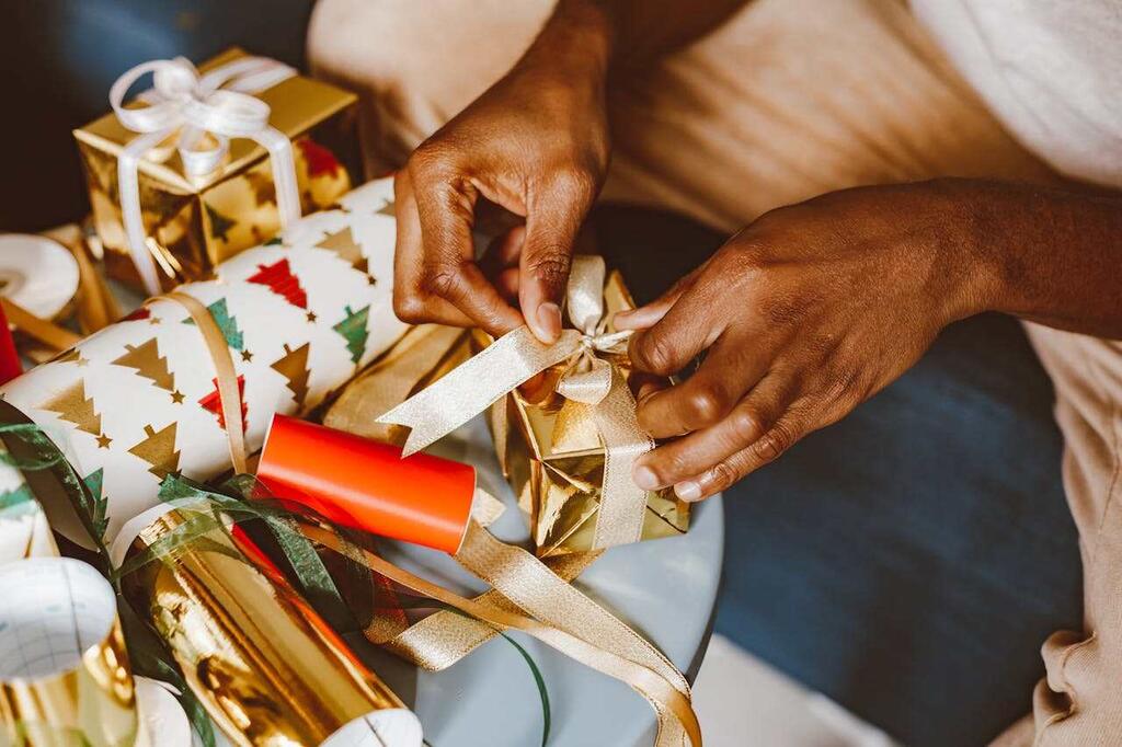 pessoa embrulhando lembrancinhas de Natal para funcionários