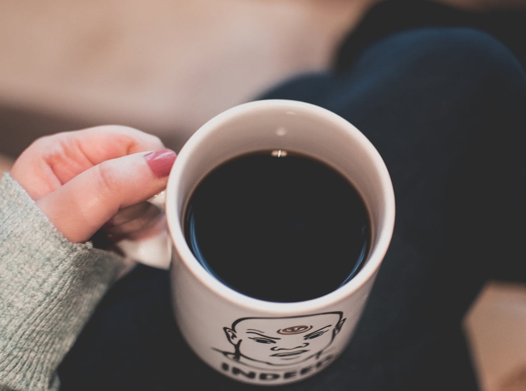 pessoa bebendo café em caneca com frases para canecas personalizadas