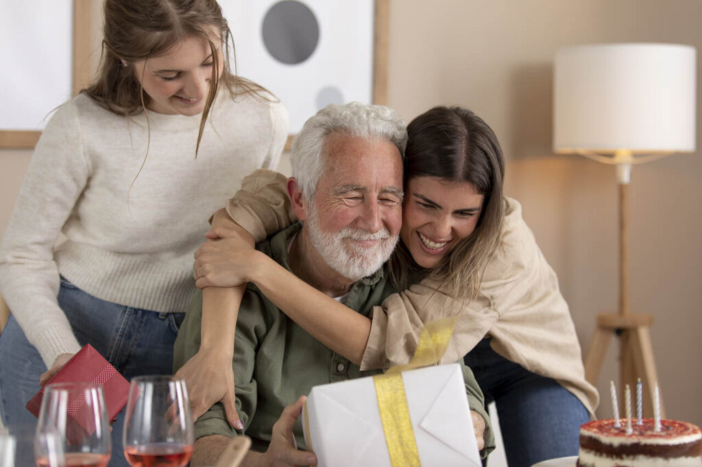 família presenteando avô com lembrancinhas no Dia dos Avós