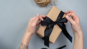 pessoa abrindo caixa de presente com kit de onboarding