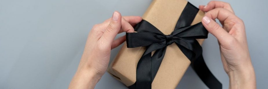 pessoa abrindo caixa de presente com kit de onboarding