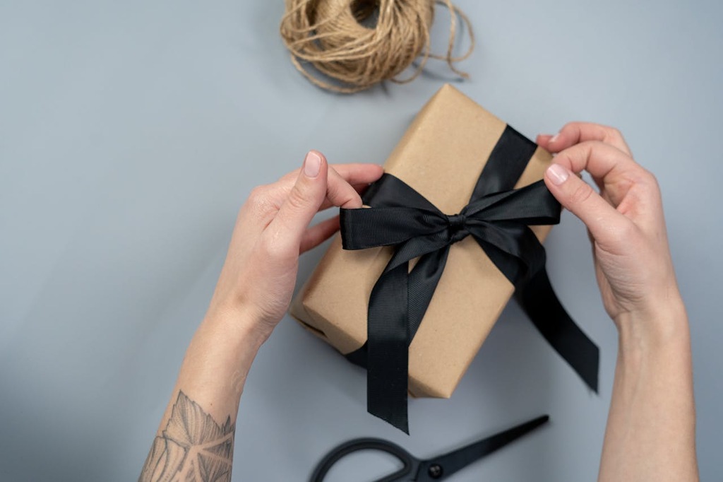 pessoa abrindo caixa de presente com kit de onboarding