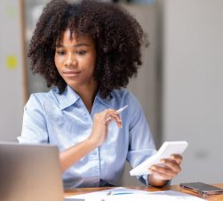 Contadora usando calculadora no escritório, representando praticidade e valorização com brindes para contadores.