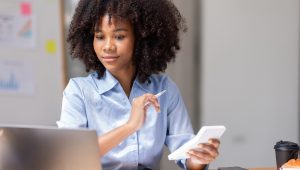 Contadora usando calculadora no escritório, representando praticidade e valorização com brindes para contadores.