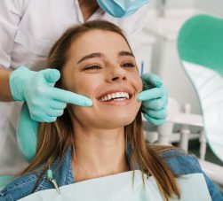 Paciente sorridente em consultório, representando os brindes para odontologia.