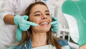 Paciente sorridente em consultório, representando os brindes para odontologia.