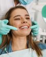 Paciente sorridente em consultório, representando os brindes para odontologia.