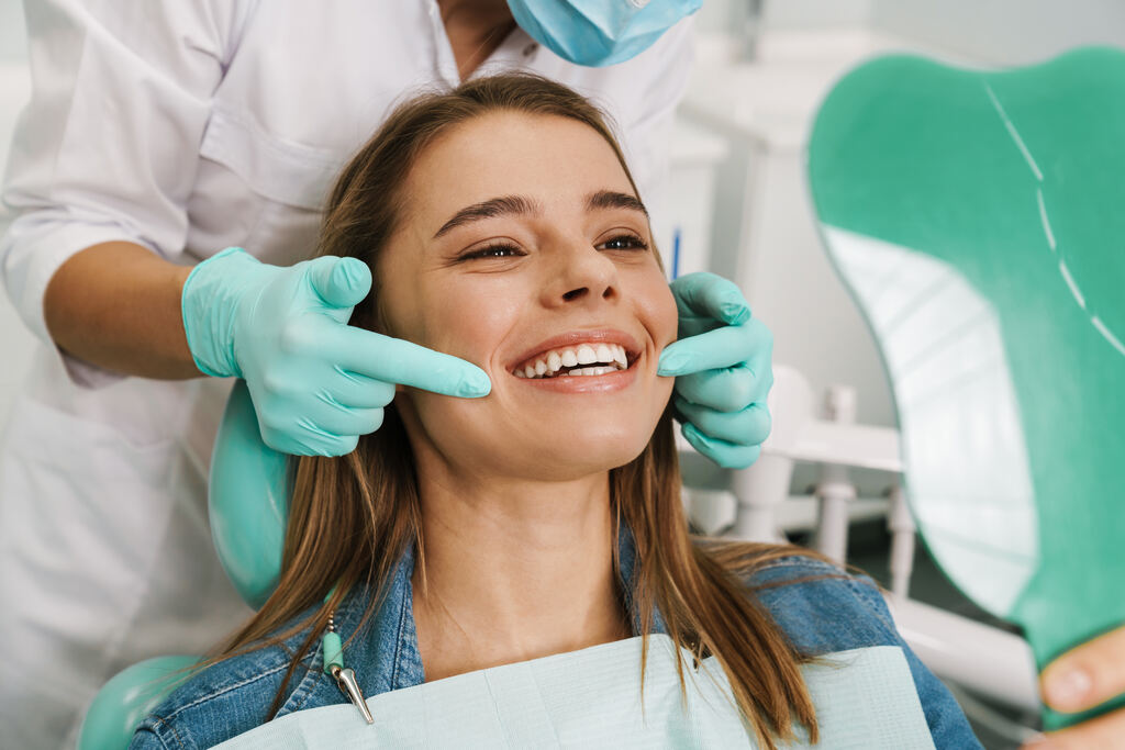 Paciente sorridente em consultório, representando os brindes para odontologia.
